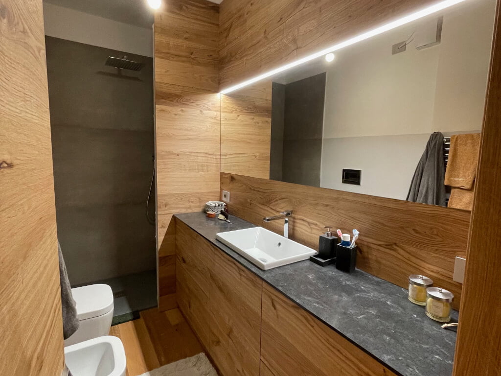 Arredamento custom per zona bagno in legno massiccio con luci led e design moderno