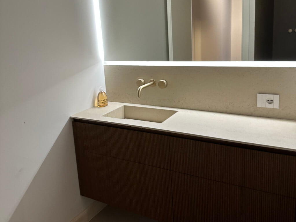 Arredamento bagno con parete illuminata a led e materiali pregiati